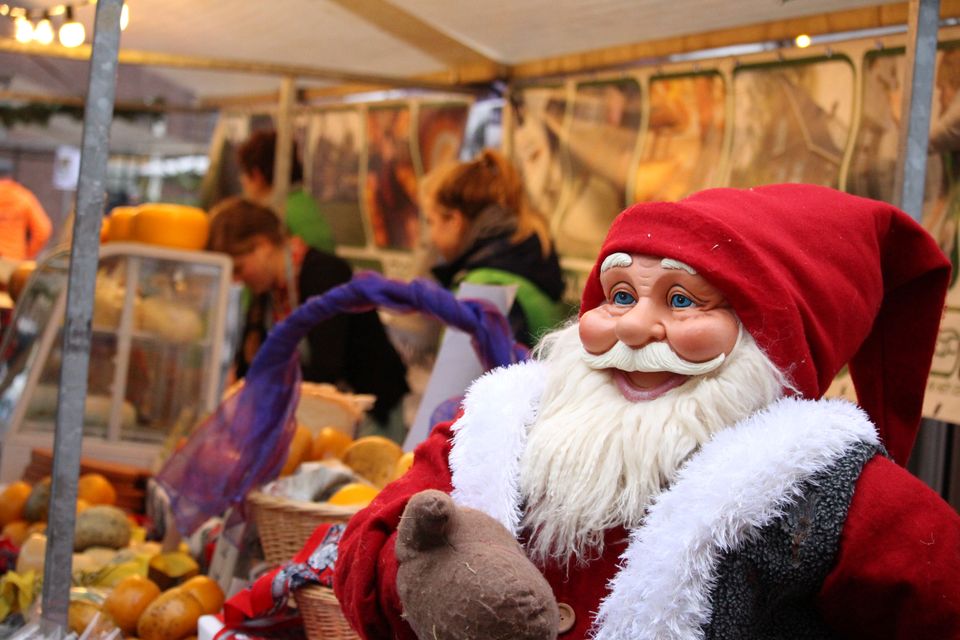 Kerstmarkt op het Kerkplein in Woerden, Groene Hart. Kerstkraam met een vrolijke kerstman tussen streekproducten en bezoekers tijdens de sfeervolle kerstmarkt in de historische binnenstad.