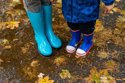Twee kinderlaarzen in een regenplas