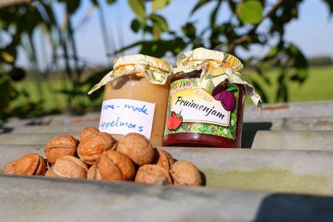 Twee potten met jam op een tafel in de boomgaard.