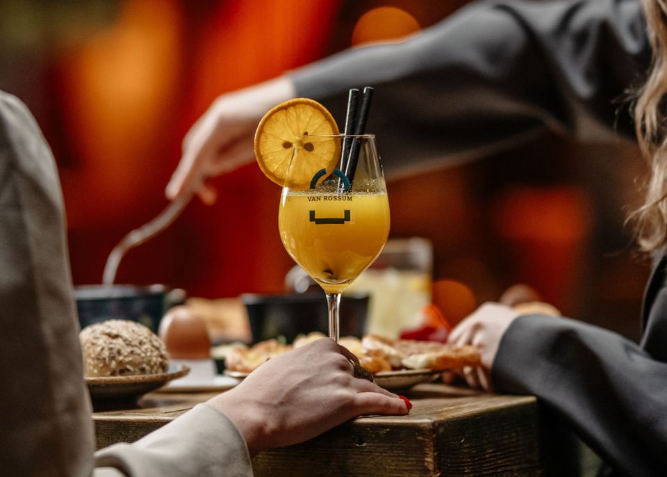 Restaurant Van Rossum in Woerden, Groene Hart, paasbrunch met cocktail met sinaasappel en brunchgerechten op tafel tijdens gezellig samenzijn in warme horecasfeer.