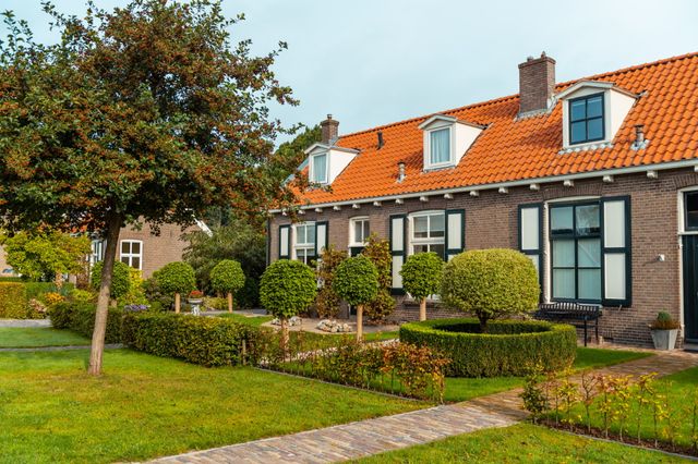Rijtje authentieke huisjes met groene voortuintjes.