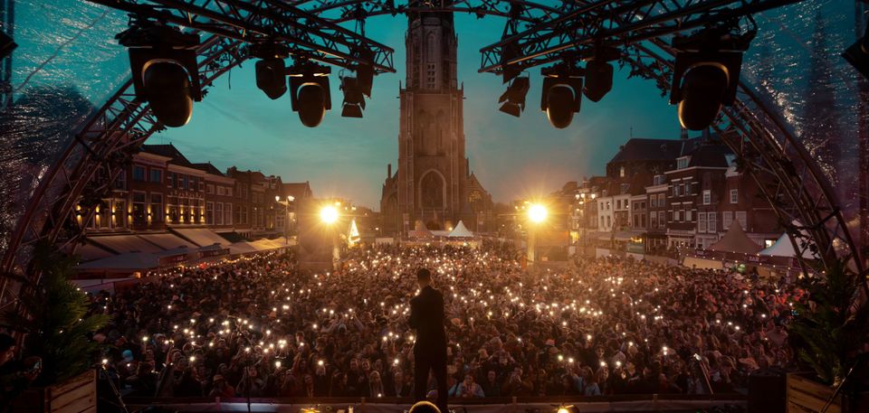 Delft Live vanaf het podium kijkend naar het publiek die voor de Nieuwe Kerk op de Markt in Delft staan
