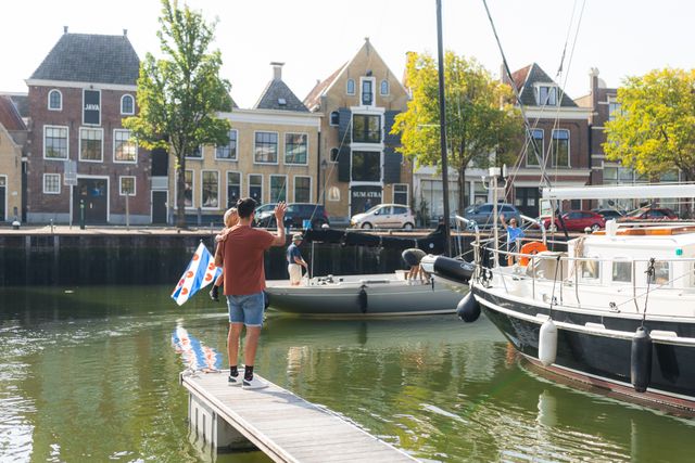 Vader en kind zwaaien naar passanten