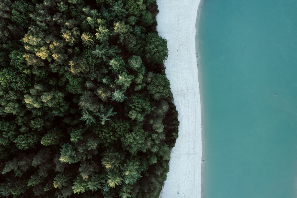 Ein Luftbild des blauen Wassers des Gasseltervelds, des weißen Sandstrandes und des angrenzenden grünen Waldes.