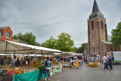 Streekmarkt op het Kerkplein in Woerden, Groene Hart, met bezoekers en marktkramen met lokale producten voor de Petruskerk. Foto: Lieke van Egmond.