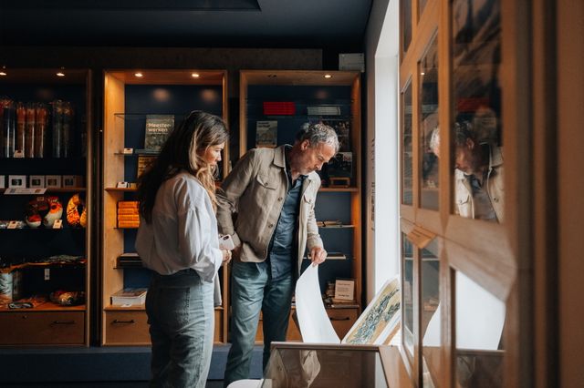 Een man en een vrouw bekijken prenten in het Van Gogh Huis Drenthe.