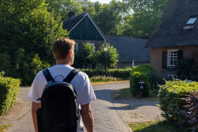 Ein Mann wandelt durch ein Dorf.