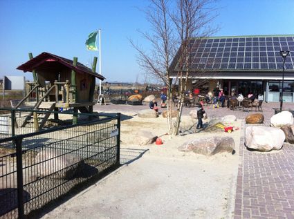 Stadsboerderij de Widiemolen met huisje voor kinderen om in te spelen en een zandbak.