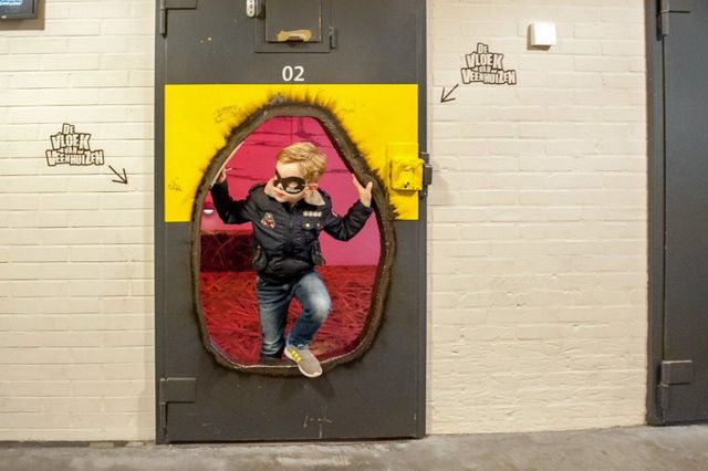 Jongetje dat door een celdeur kijkt in het Gevangenismuseum.