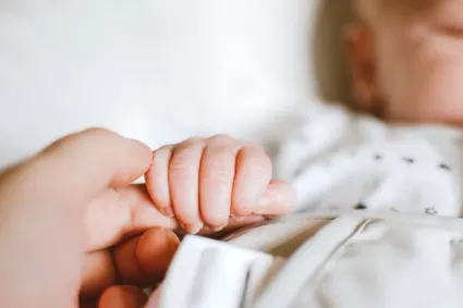 a baby holding a finger