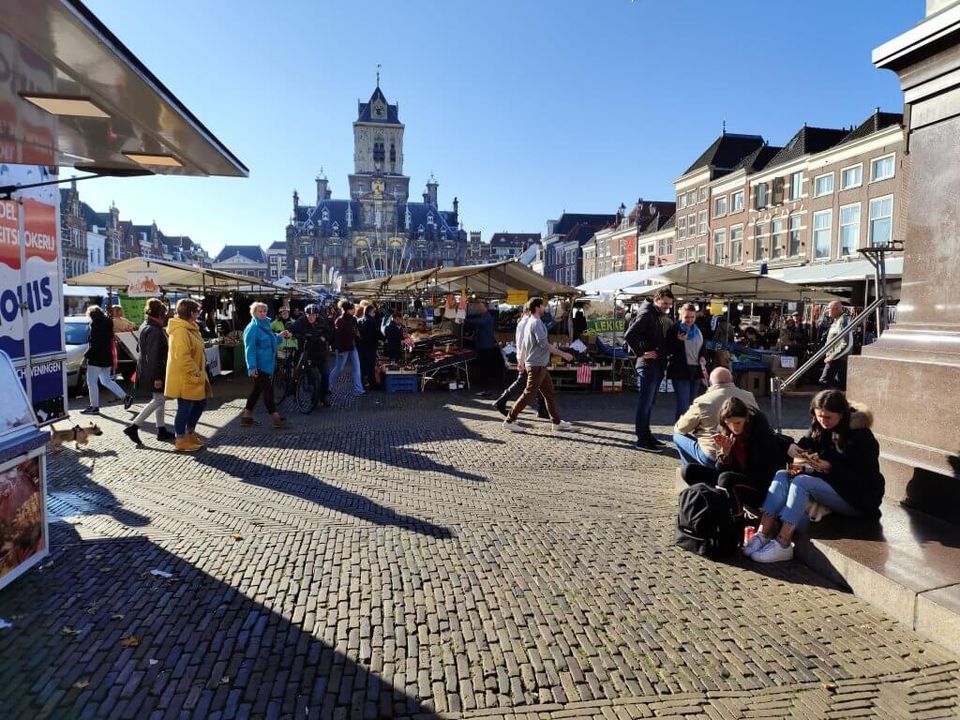 Warenmarkt op donderdag in Delft met uitzicht op kraampjes en het stadhuis