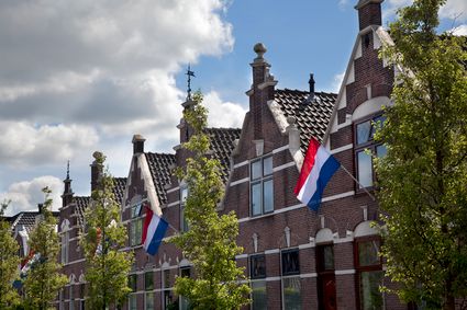 Historische panden met oude gevels in Woerden met de vlag uit voor koningsdag.
