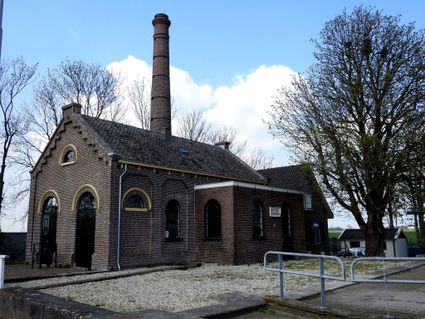 Een karakteristiek beeld van het oude gemaal in Kamerik, met zijn robuuste bakstenen gevels, hoge schoorsteen en sierlijke boogramen. Het gebouw ademt de industriële geschiedenis van het polderlandschap en vormt, omgeven door bomen en weidse uitzichten, een prachtige blikvanger in het Groene Hart.