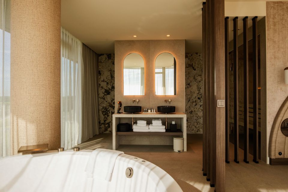 Hotel Van der Valk Woerden, Woerden, Groene Hart, luxe wellnesssuite met bubbelbad, dubbele wastafel, privésauna en stijlvolle badkamer voor een ontspannen hotelovernachting.