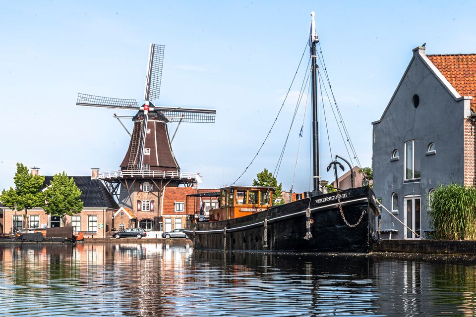 Ein Boot und eine Mühle auf dem Wasser in Meppel