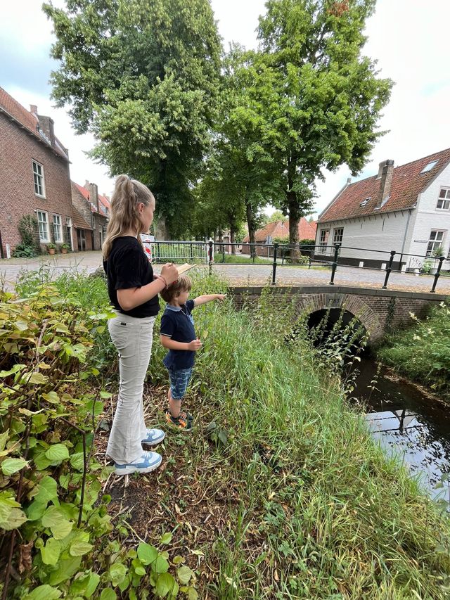 Two children are working on an assignment during proverb route Heusden.