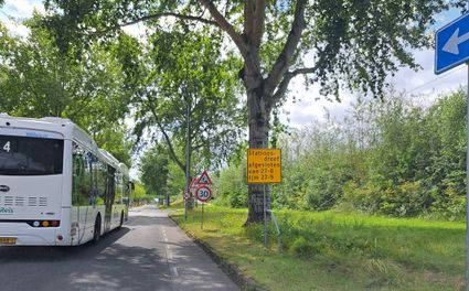 Bus rijdt langs informatiebord over afgesloten dreef