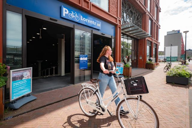 Picture of a girl holding her bike while she walks