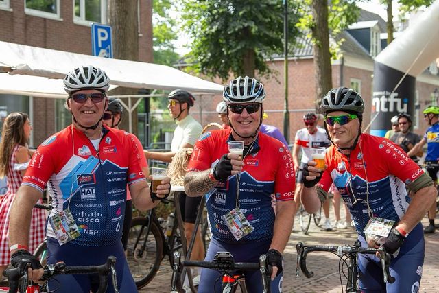 Drie wielrenners hebben de tocht net uitgereden en genieten van een biertje