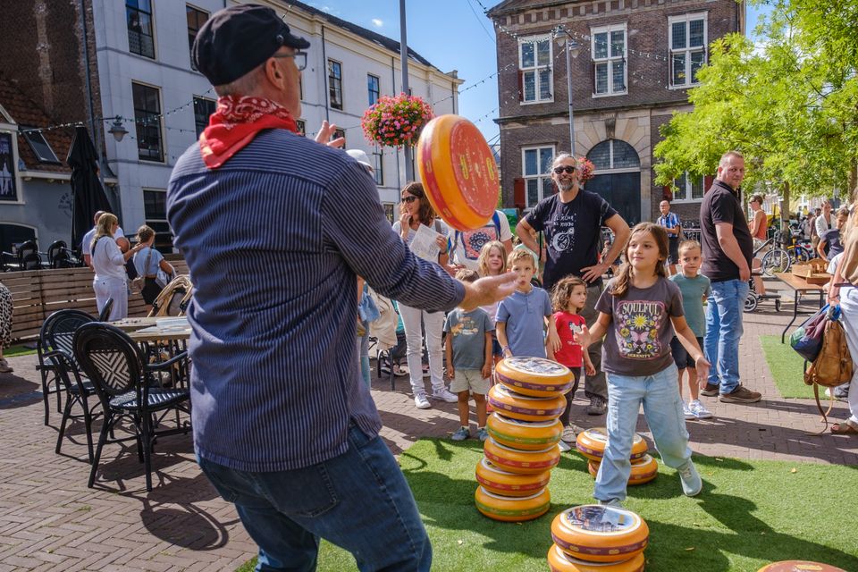 Kinderkaasmarkt tijdens de Kaasmarkt in Gouda, regio Groene Hart, met spelende kinderen en publiek op historisch plein tijdens gezinsvriendelijk evenement in de binnenstad.