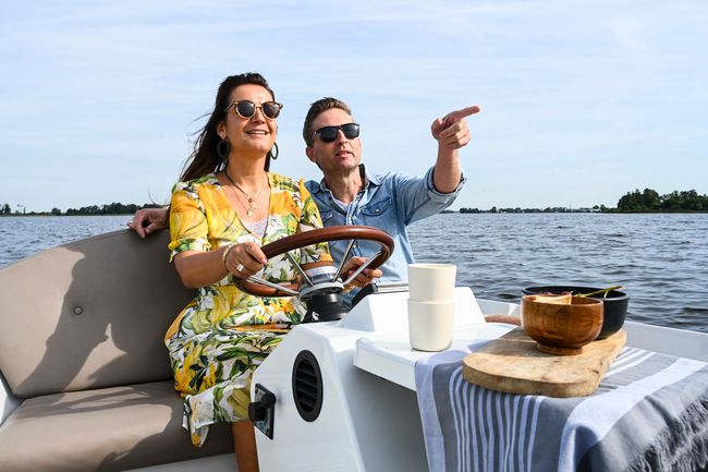 Man en een vrouw in een sloepje over de Loosdrechtse Plassen