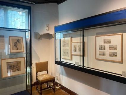 Tentoonstellingsruimte in Museum Woerden met ingelijste schetsen van Vreedenburgh en Schotel in vitrines en aan de muur.