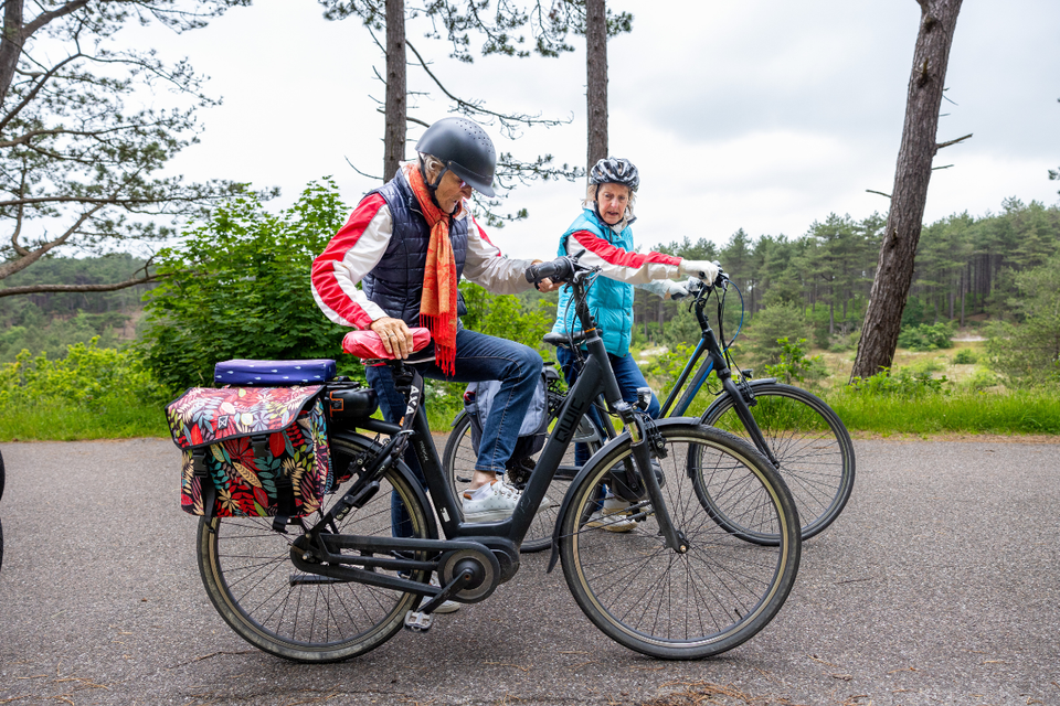senioren koppel stapt op de fiets