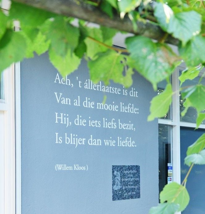 Een foto van het gevelgedicht van Willem Kloos.