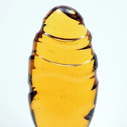Geel/goud kleurige ovale glas sculptuur met de titel 'the long and winding road to Neverland 2026' .