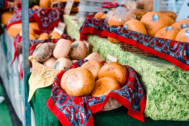 Boerenkazen en streekproducten op een marktkraam tijdens de Boerenkaasmarkt in Woerden. Een traditioneel evenement waar bezoekers ambachtelijke kazen uit het Groene Hart kunnen proeven en kopen.