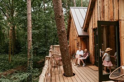 Houten boomhuis met gezin op veranda