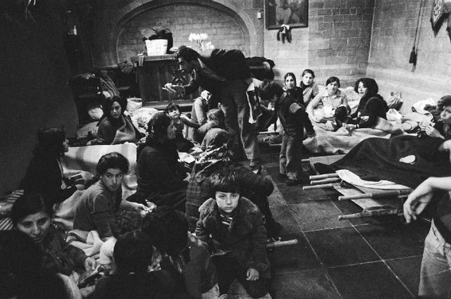 De Turkse vluchtelingen op bedden van het Rode Kruis.