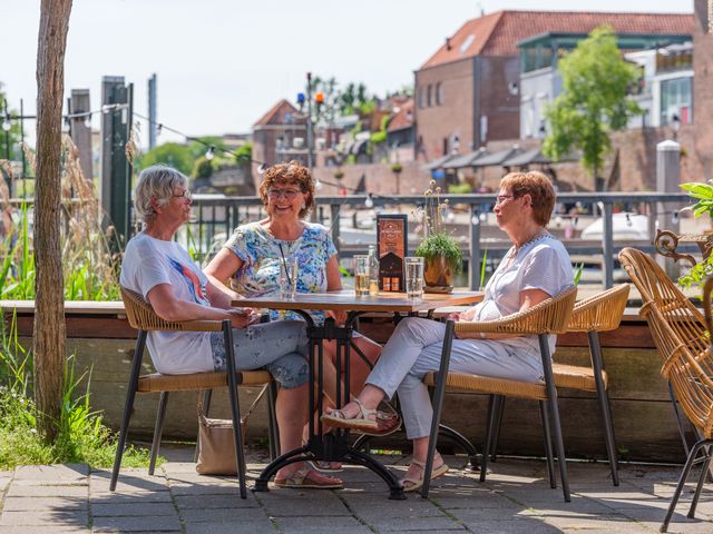 Drie personen zitten in de zon op het terras van de Houtloods in Leerdam