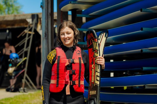 Meisje met waterski's in haar handen.