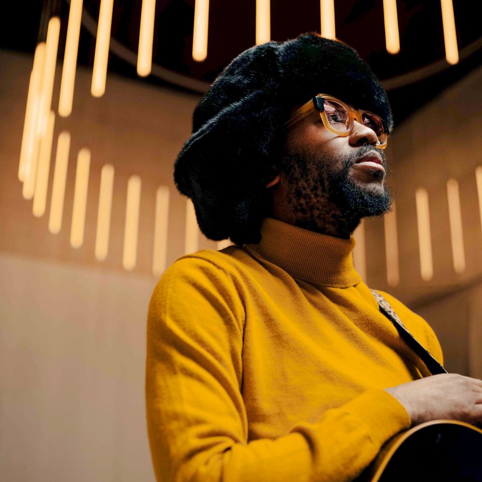 Een man met een geel colletje en gitaar