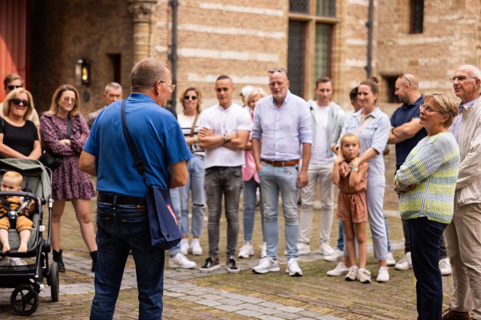 Een gids staat voor een groep tijdens een stadswandeling in Bergen op Zoom.