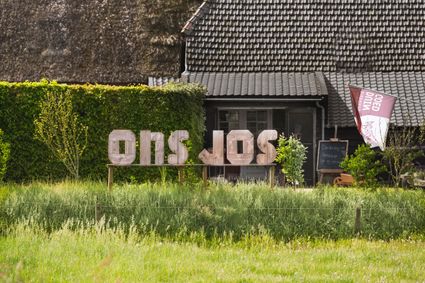 Boerderijwinkel met letters ONS JOS voor de deur.