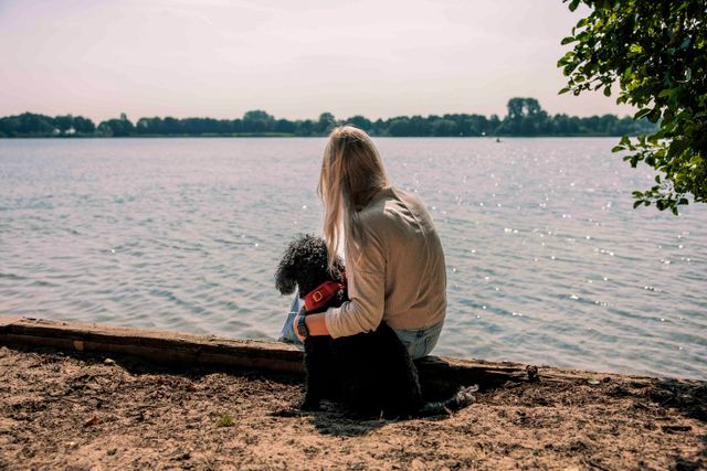 vrouw met een hond bij het water