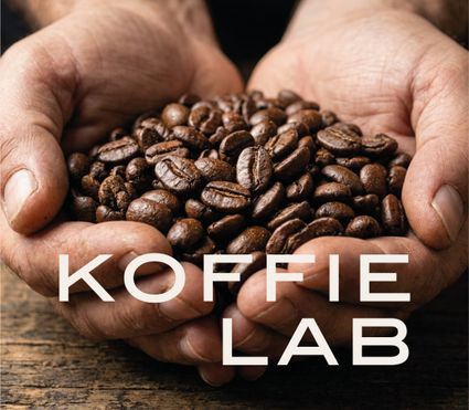 Workshoplocatie Koffie Lab De Hall in Woerden, Groene Hart, met geroosterde koffiebonen in twee handen en het opschrift ‘Koffie Lab’, passend bij een koffie workshop en groepsactiviteit.