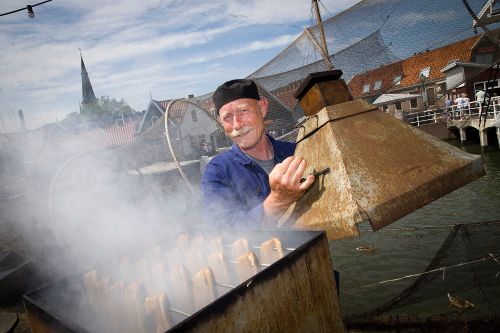 Een man die vis aan het roken is tijdens de Monnickendammer Visdagen.
