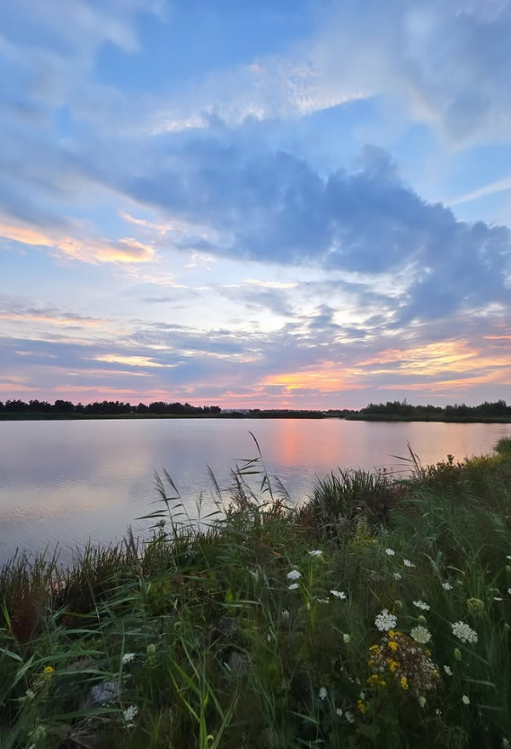 Ondergaande zon over het water bij Parkgebied Oranjewoud.