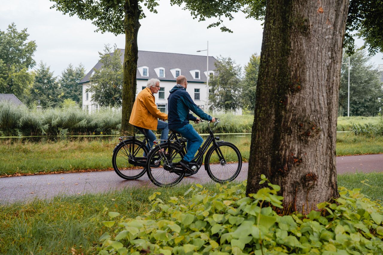 Fietsers langs herenhuis Karelstein aan het kanaal.