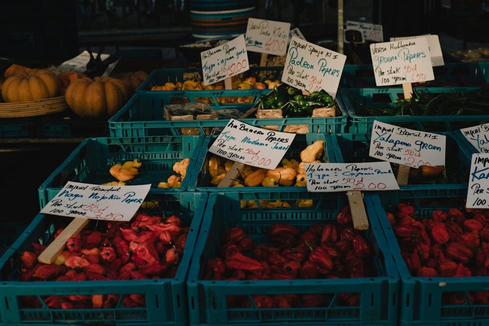 Een aantal kratten met groenten in een marktkraam.