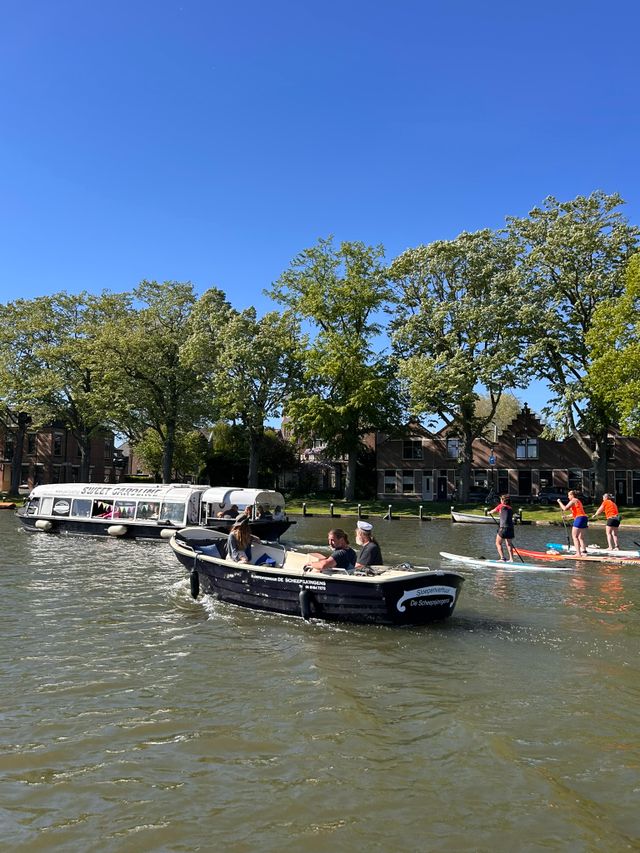 Waterrecreatie op de Singel van Woerden, Groene Hart, met sloep van De Scheepsjongens, suppen van Sportsaeck op het water en rondvaartboot Sweet Caroline langs de historische binnenstad tijdens een zonnige dag.
