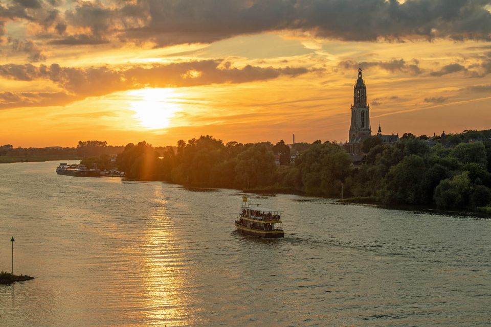 De Blauwe Bever vaart met de ondergaande zon langs Rhenen