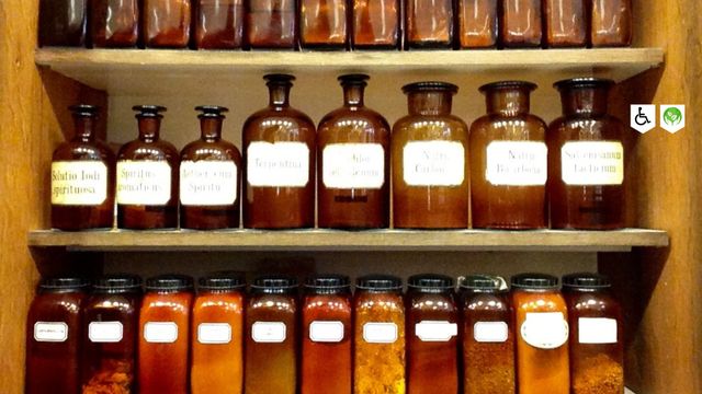 Speciaalzaak Drogisterij Stouthart Woerden, provincie Utrecht, Groene Hart, klassieke apothekersflessen en glazen potten met kruiden, oliën en natuurlijke verzorgingsproducten in een authentiek interieur.