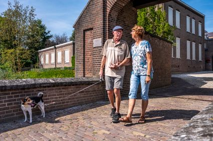 Ouder stel wandelt met hond door Megen