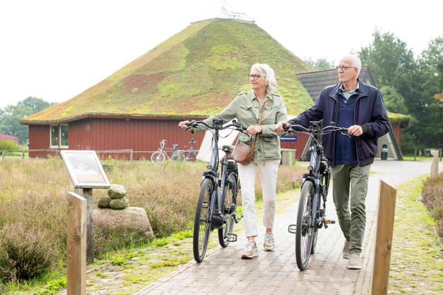 Twee mensen naast de fiets bij het Bezoekerscentrum Dwingelderveld in Ruinen.