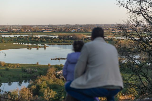 Vader en zoon kijken uit over het waterrijke landschap van Rhenen