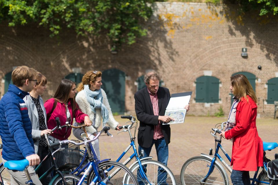 Groepje fietsers op een fort met een vrijwillige gids.